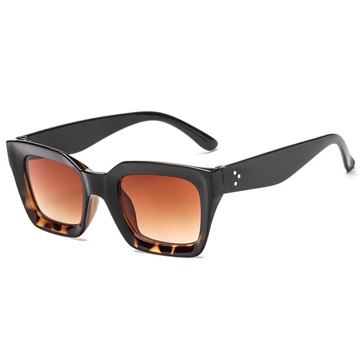 Black vintage-style sunglasses with thick plastic frames and dark rectangular lenses, featuring a subtle cat-eye shape. - Image 3