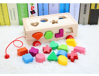 Happy baby playing with a wooden shape matching building block toy, featuring a natural wood box and colorful geometric shapes. - Image 4