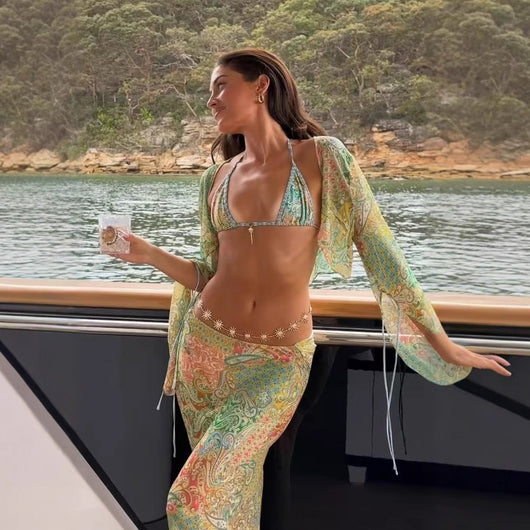 Halterneck two-piece swimsuit with a vibrant paisley print in blue, green, orange, and pink, featuring light blue straps. - Image 4