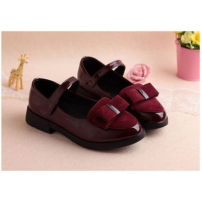 Black patent Mary Jane shoes for girls with a strap, round toe, and a black suede bow with a silver accent. - Image 5
