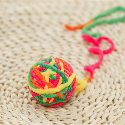 Colorful plush yarn ball cat toy in pink, blue, and white, with a long trailing strand, on a light background. - Image 14