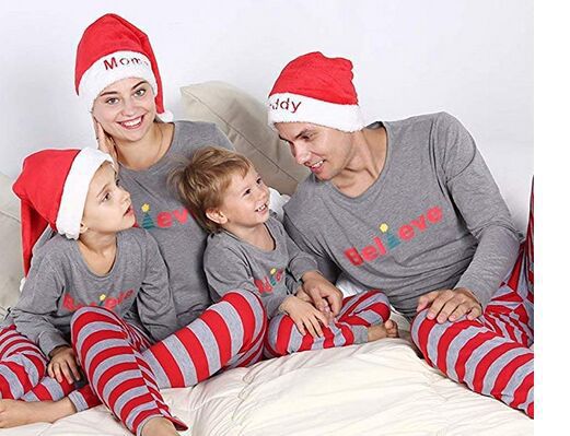 Family of four in matching grey long-sleeve tops and red striped pants, posing in a festive holiday setting. - Image 7