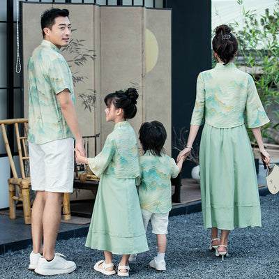 Mother and daughter in matching light green Chinese style cheongsam suits with patterned tops and solid skirts. - Image 8