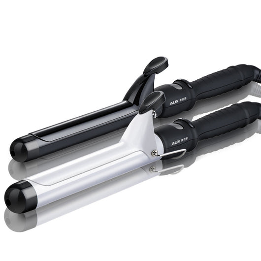 Two AUX curling irons, one black and one white, with ceramic glaze barrels and black handles, on a reflective surface.