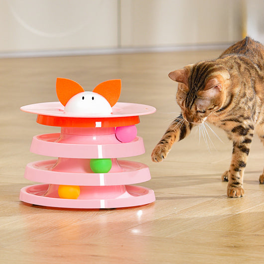 Brown tabby cat sniffing a black and orange multi-level rotating cat plate toy with colorful balls and bunny ears. - Image 7