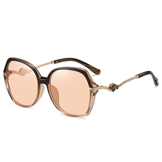 Oversized round-frame sunglasses with pink polarized lenses, translucent pink and brown frame, and gold floral temple accents. - Image 8