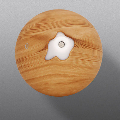 Teardrop-shaped aromatherapy humidifier with light wood grain finish, emitting mist and glowing with purple LED light. - Image 16