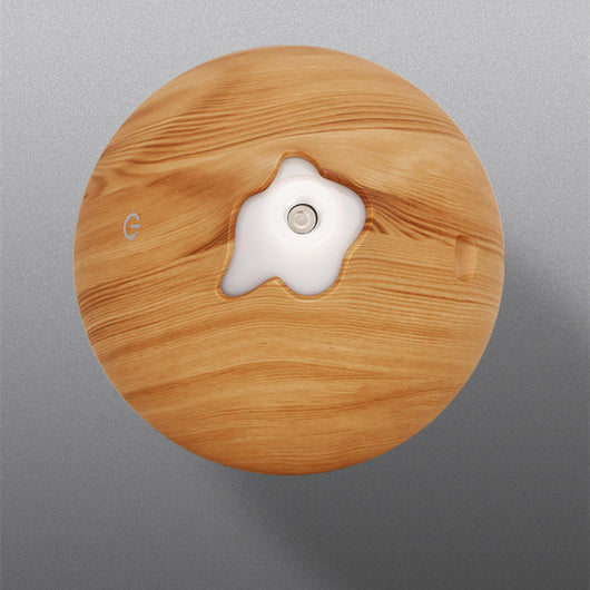 Teardrop-shaped aromatherapy humidifier with light wood grain finish, emitting mist and glowing with purple LED light. - Image 16