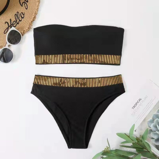 Black bandeau bikini with gold striped trim and matching high-waisted bottoms on a white surface. - Image 8