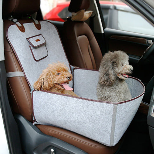 Light grey pet car seat with brown trim on a car's front passenger seat, holding two small dogs. Includes a black pet seatbelt tether.