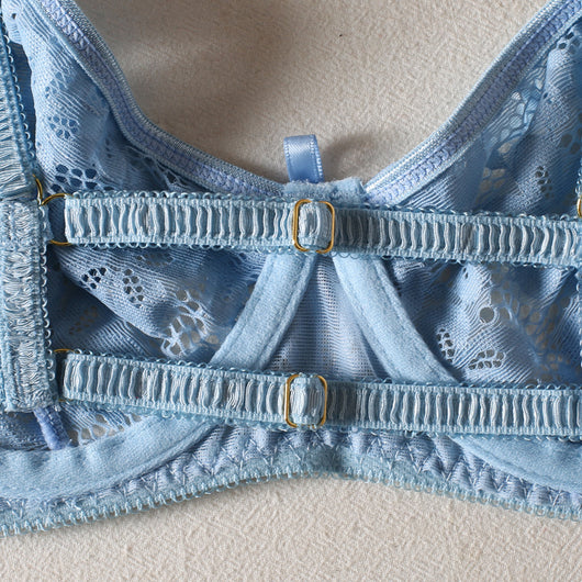 Light blue lace bralette and thong lingerie set with bow details and ruffle trim, displayed on a light surface. - Image 11