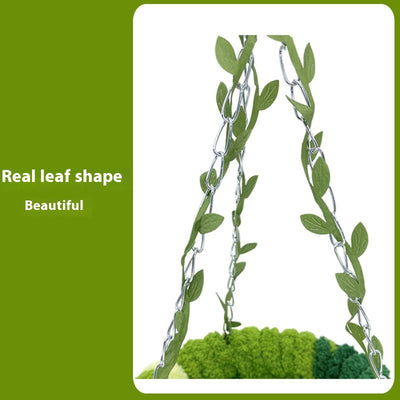 Small forest style plush bird hammock in green and yellow, hanging from a chain with artificial leaves. - Image 3