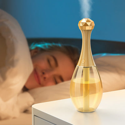 Mini silent portable humidifier shaped like a perfume bottle, with a clear body and a gold ribbed neck and faceted cap. - Image 14