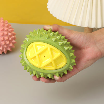 Pink and yellow durian-shaped chew toy with soft spikes, designed for pets, on a white display block. - Image 5