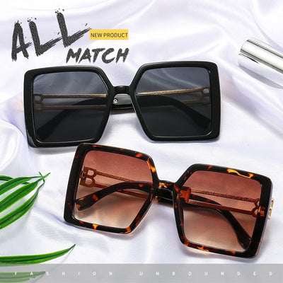Women's large frame square sunglasses with black plastic frames, purple gradient lenses, and gold-tone metal temples.