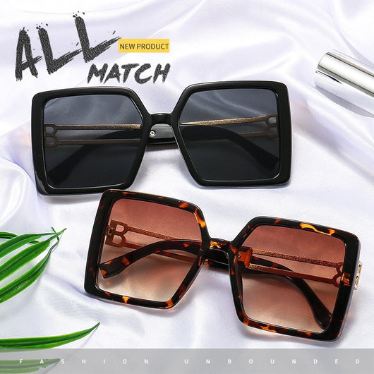 Women's large frame square sunglasses with black plastic frames, purple gradient lenses, and gold-tone metal temples.
