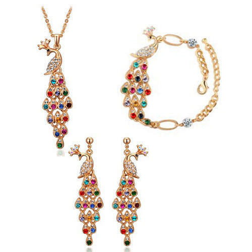 Gold tone peacock bridal jewelry set with colorful crystal accents, including a necklace, bracelet, and dangle earrings.