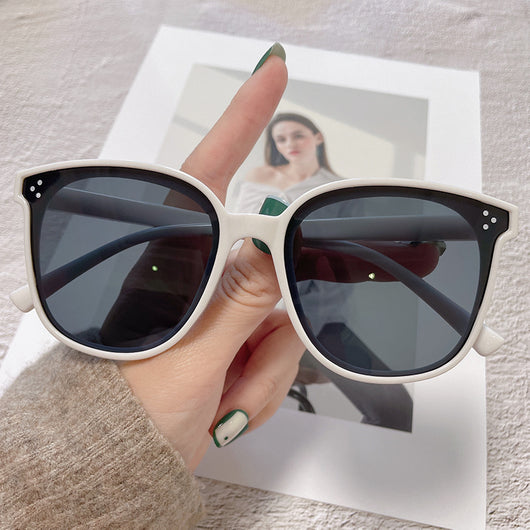 Cream square-style sunglasses with dark lenses, featuring small silver accents on the frame corners.