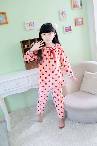 Young woman wearing a pink coral fleece thermal pajama set with white and red polka dots and ruffled hems. - Image 2