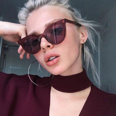 White vintage cat-eye sunglasses with dark lenses, angled on a clean white background.