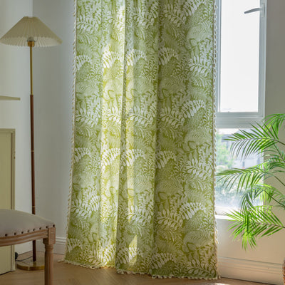 Green curtain with white leafy botanical pattern and cream tassels, hanging in a window with natural light. - Image 3