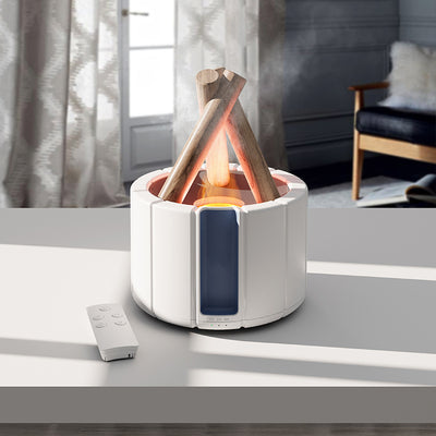 Dark gray simulated flame aromatherapy machine with a remote control, emitting a warm, flame-like light and mist.