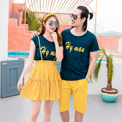 Family of four in matching dark blue short-sleeved tops with yellow text and yellow bottoms, posing outdoors. - Image 5