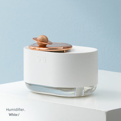 White USB rechargeable mini humidifier with a rose gold top accent and a wooden planet decoration. - Image 13