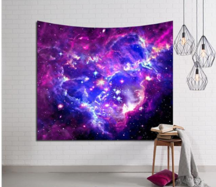 Purple and blue galaxy tapestry with stars, hung on a white brick wall, perfect for cosmic home decor.