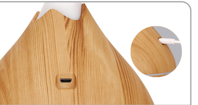 Teardrop-shaped aromatherapy humidifier with light wood grain finish, emitting mist and glowing with purple LED light. - Image 10