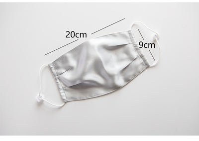 Light pink double layer silk face mask with adjustable white ear loops on an open magazine. - Image 15