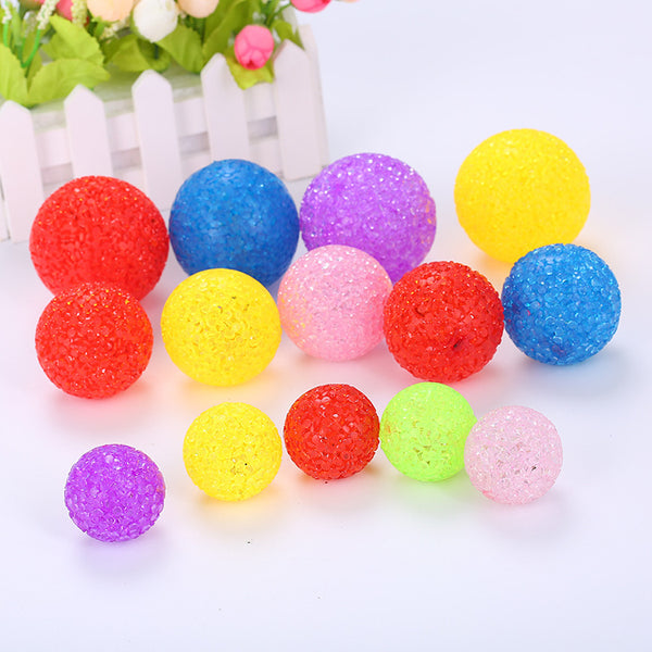 Assortment of colorful textured plastic cat toy balls in red, yellow, blue, purple, pink, and green.