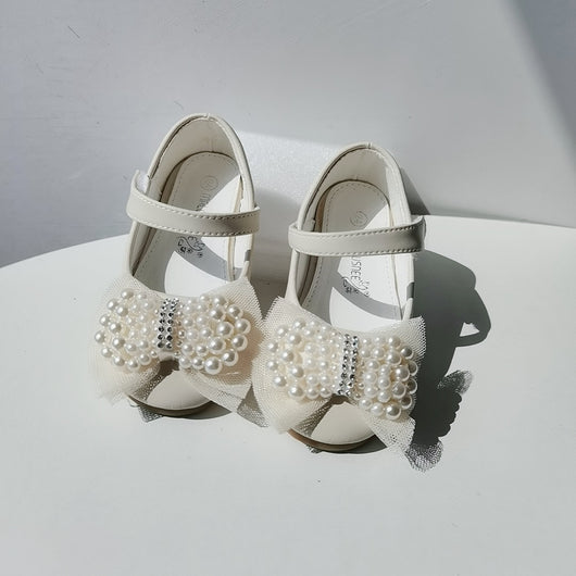 Beige girls' princess shoes with pearl and rhinestone bows, featuring a flat heel and a convenient Velcro strap. - Image 3