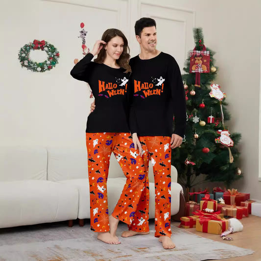 Family of four wearing matching black and orange Halloween long-sleeve pajamas with ghost and bat prints. - Image 2