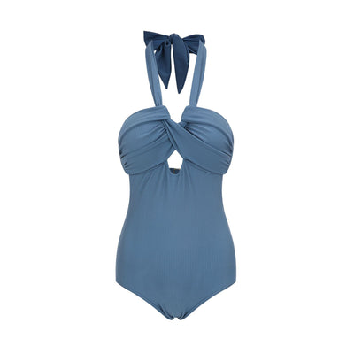 Woman wearing a taupe ribbed one-piece swimsuit with a halter neckline and twisted bust detail on a sandy beach. - Image 11