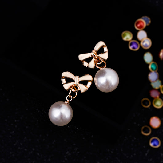 Aretes Elegantes de Corazón con Moño de Circonia y Perla - Image 3
