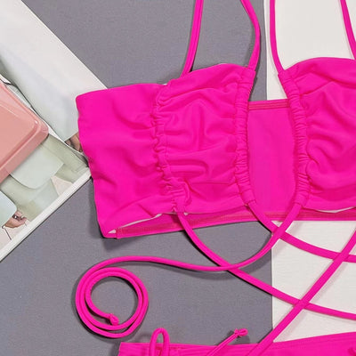 Neon pink lace-up bikini with a bandeau top and high-cut bottom, laid flat on a split gray and white background. - Image 4