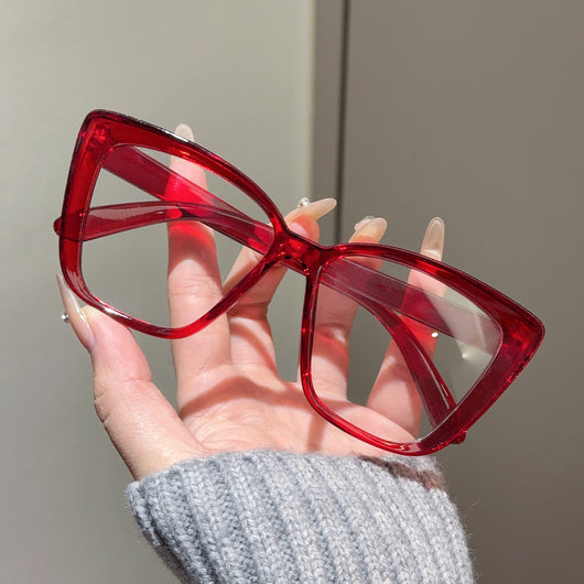 Clear large-frame square glasses held by a hand in a grey knitted sweater, showcasing the transparent plastic frame. - Image 22
