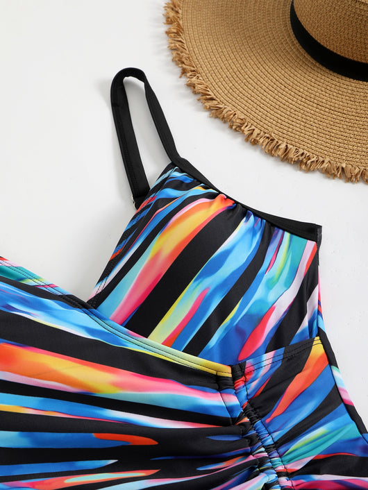 Woman in a navy and white striped tankini swimsuit with a wrap-front and side drawstring, holding a woven bag. - Image 25