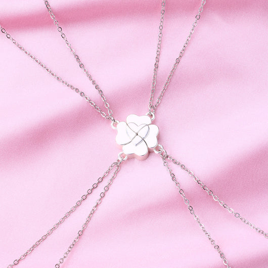Four silver-colored necklaces, each with a half-heart charm that forms a four-leaf clover when combined, on pink satin. - Image 10