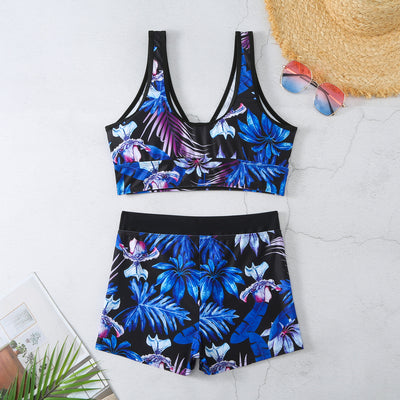 Two-piece swimsuit with a black background and vibrant pink and purple tropical floral print. Features a V-neck crop top and high-waisted boxer shorts. - Image 22