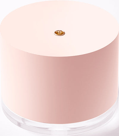 Pink cylindrical mini wireless humidifier with a clear base and a small gold mist outlet on top. - Image 4