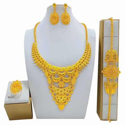Gold-colored women's jewelry set with ornate floral and filigree designs, including a necklace, drop earrings, bracelet, and ring.