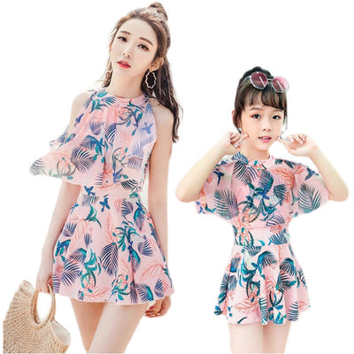 Mother and daughter matching swimsuits with blue and pink tropical leaf print. Adult halter top and skirt, child's ruffle top and skirt. - Image 6