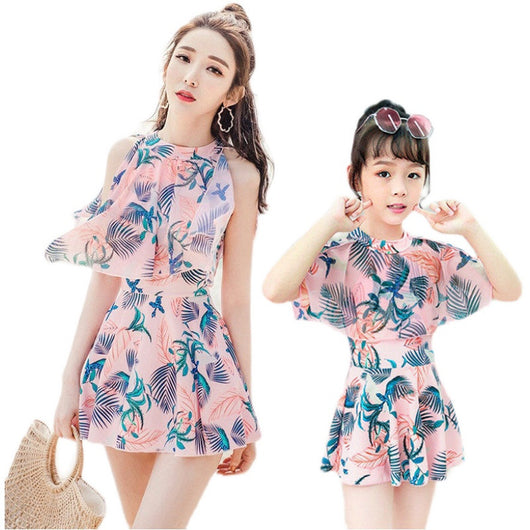 Mother and daughter matching swimsuits with blue and pink tropical leaf print. Adult halter top and skirt, child's ruffle top and skirt. - Image 6