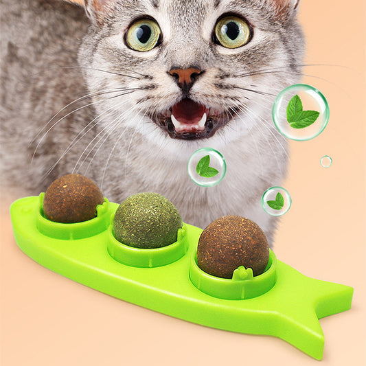 Pink fish-shaped cat molar stick toy with three compartments holding green and brown catnip or silvervine balls. Three clear plastic dome covers are shown.
