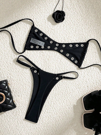 Black bandeau bikini swimsuit with thin straps and a gold-toned abstract ring detail on the top, paired with matching string bottoms. - Image 41