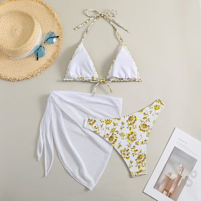 White and yellow floral print three-piece bikini set with a halter triangle top, high-cut bottom, and sheer white sarong. - Image 22