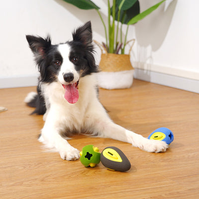 Green and yellow avocado-shaped rubber dog chew toy with a textured surface and a treat dispensing slot.