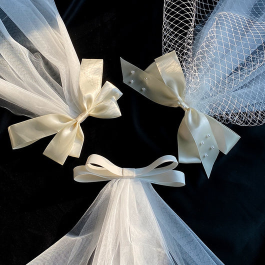 White birdcage veil with a cream satin bow and faux pearls, attached to a woven straw base, 80cm yarn length. - Image 3